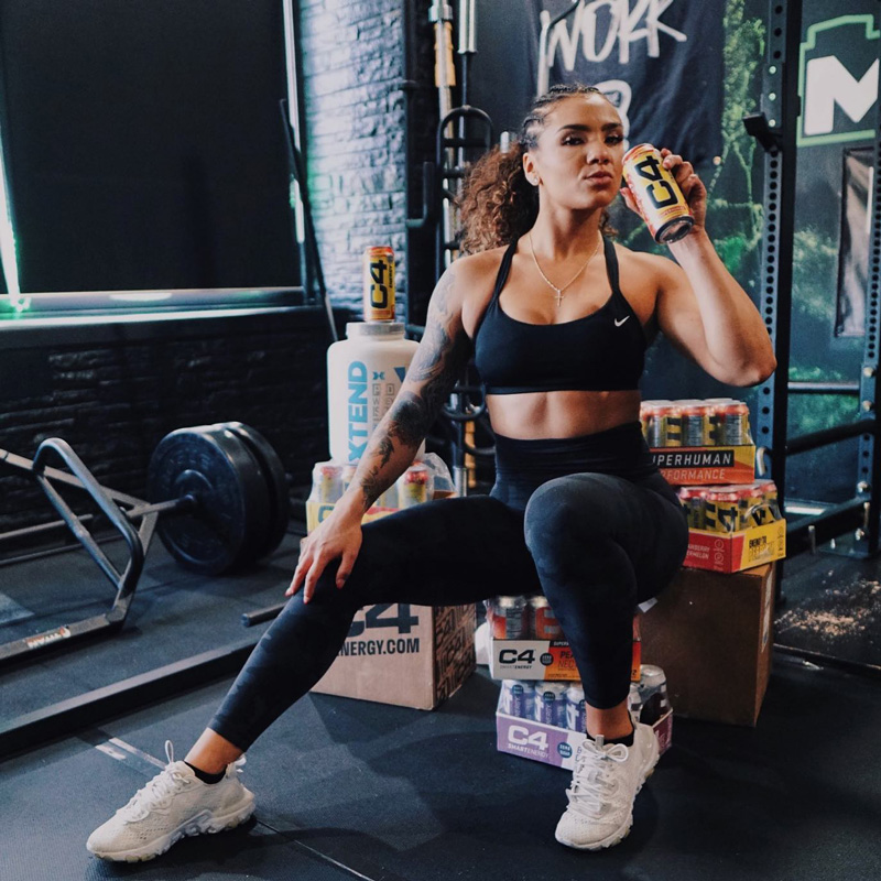 The coach stands in a lunge while holding a kettlebell in each hand.